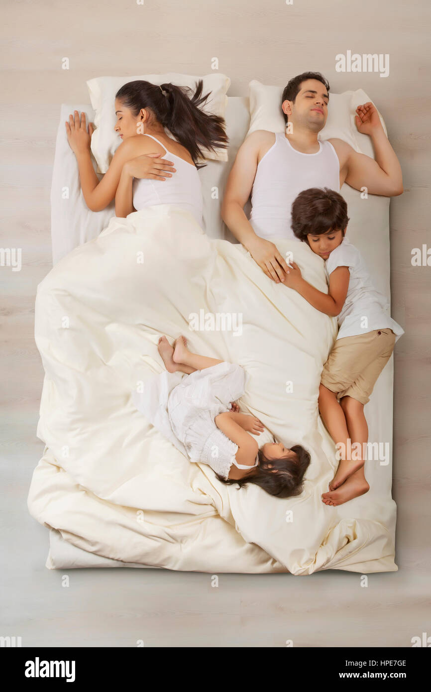 Vierköpfige Familie schlafend im Bett Stockfoto