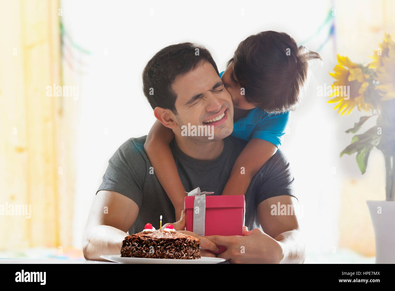 Sohn seines Vaters mit Geburtstagsgeschenk überraschen Stockfoto