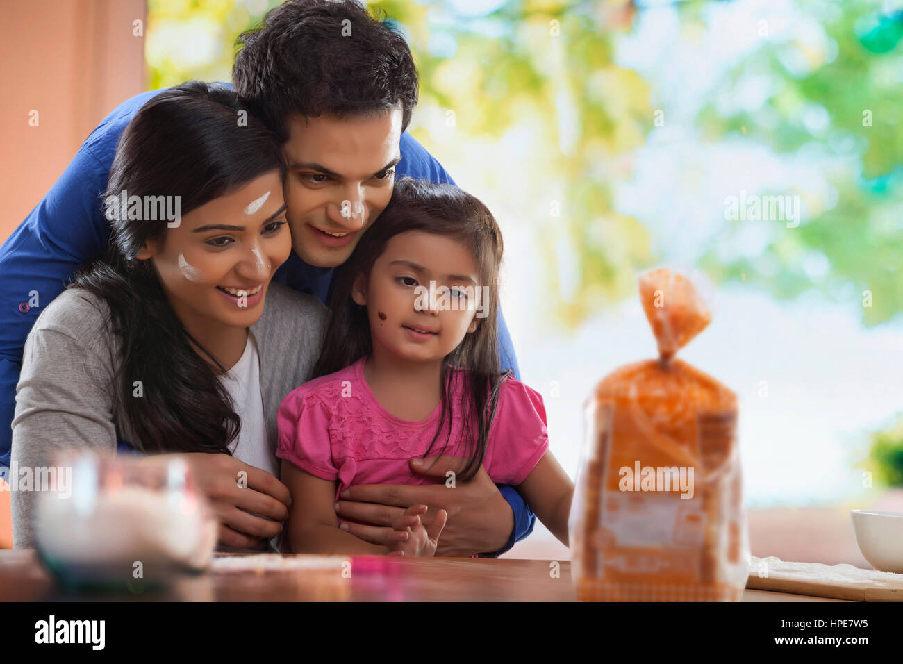 Glückliche Eltern mit Tochter Backen Plätzchen in Küche Stockfoto