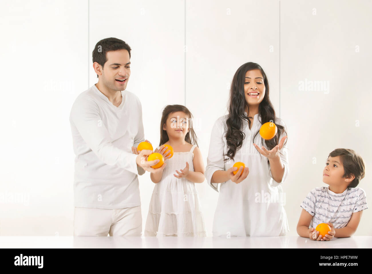 Familie jonglieren mit Orangen Stockfoto