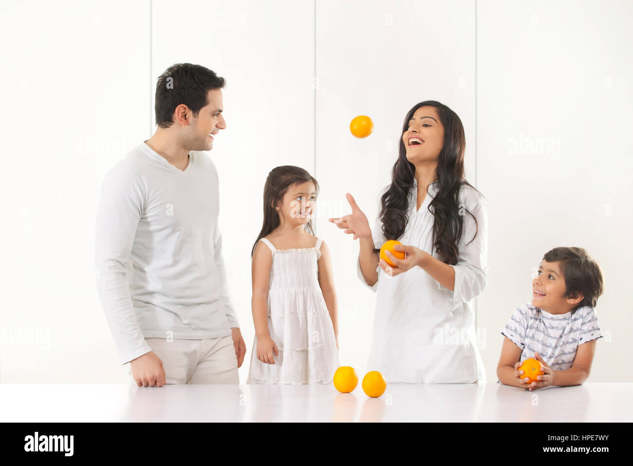 Mutter mit ihrer Familie mit Orangen jonglieren Stockfoto