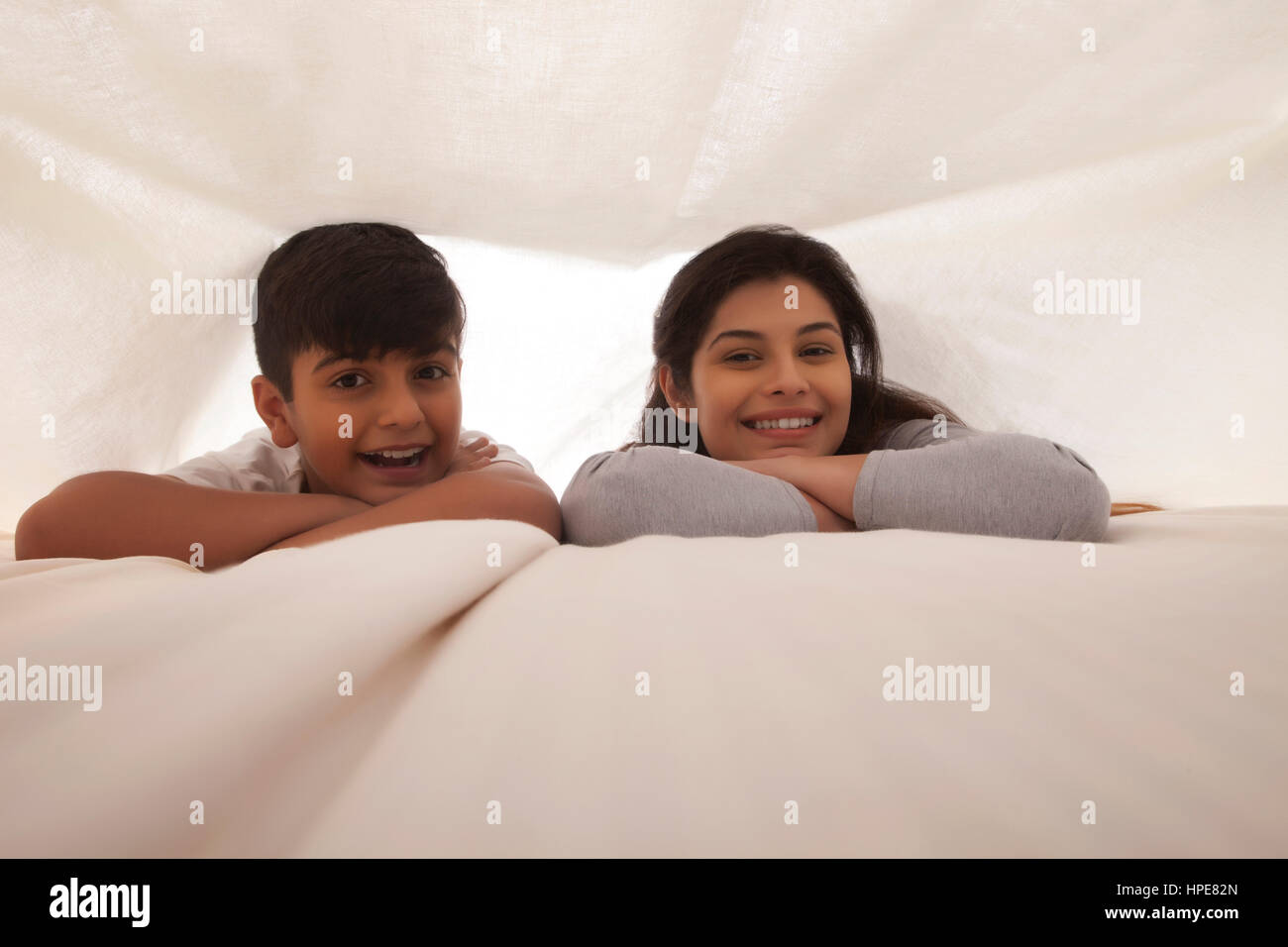 Lächelnde Mutter und Sohn Spaß im Schlafzimmer Stockfoto
