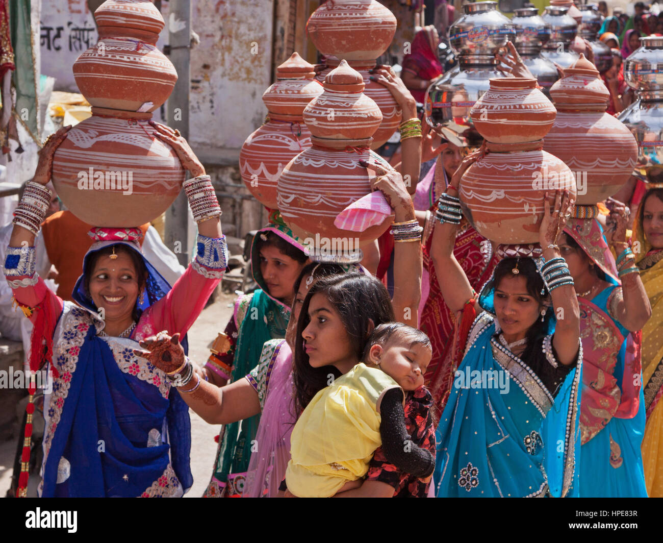 Frauen tragen symbolische Schalen auf ihren Köpfen in einer Prozession, der seinen Weg durch die Straßen von Deogarh in Rajasthan im Rahmen der Hochzeitsfeier Stockfoto