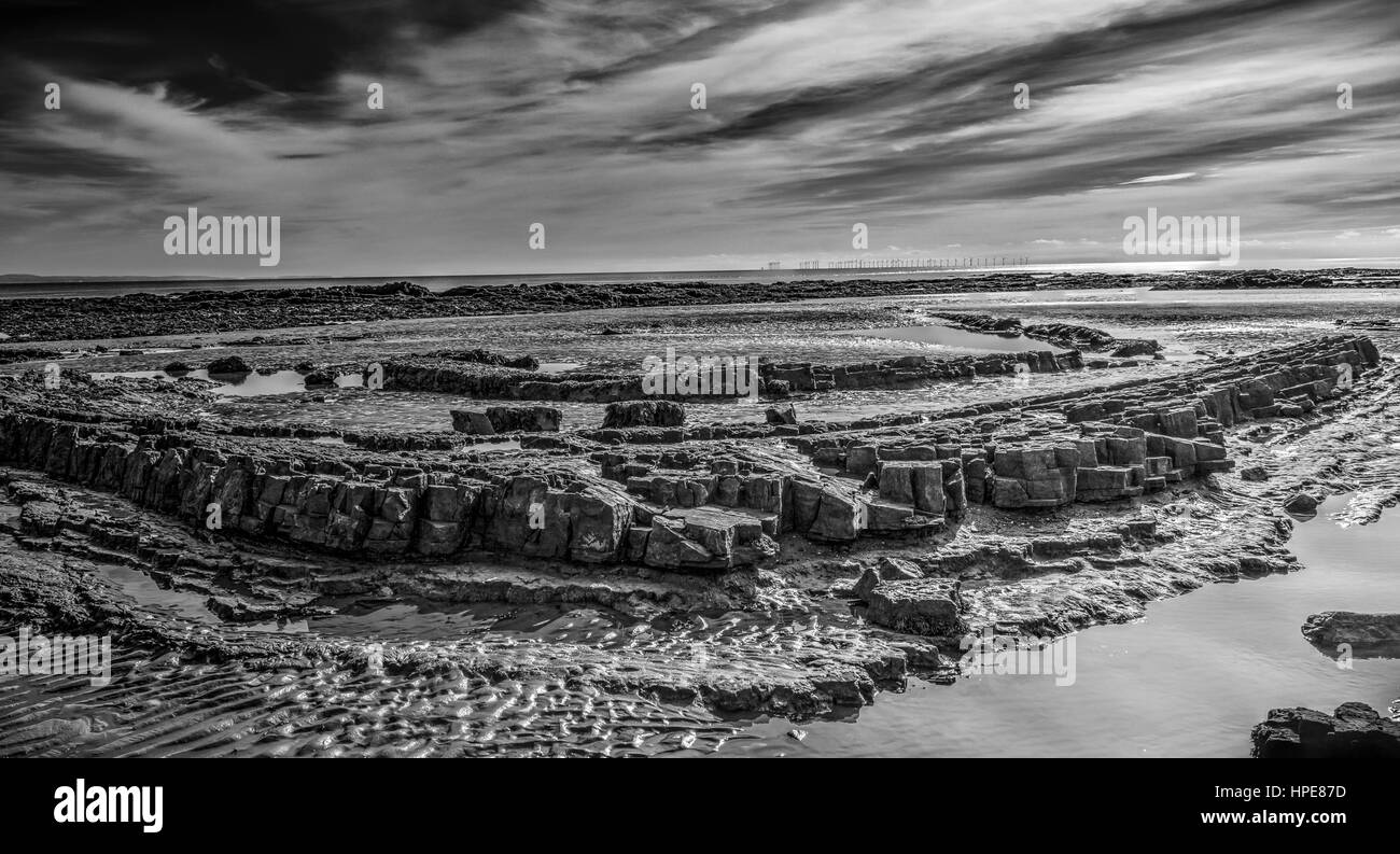 Konzentrische Felsformationen am Souherness Strand, Dumfries and Galloway, Schottland, Großbritannien. Monochrome Letterbox-Format. Stockfoto
