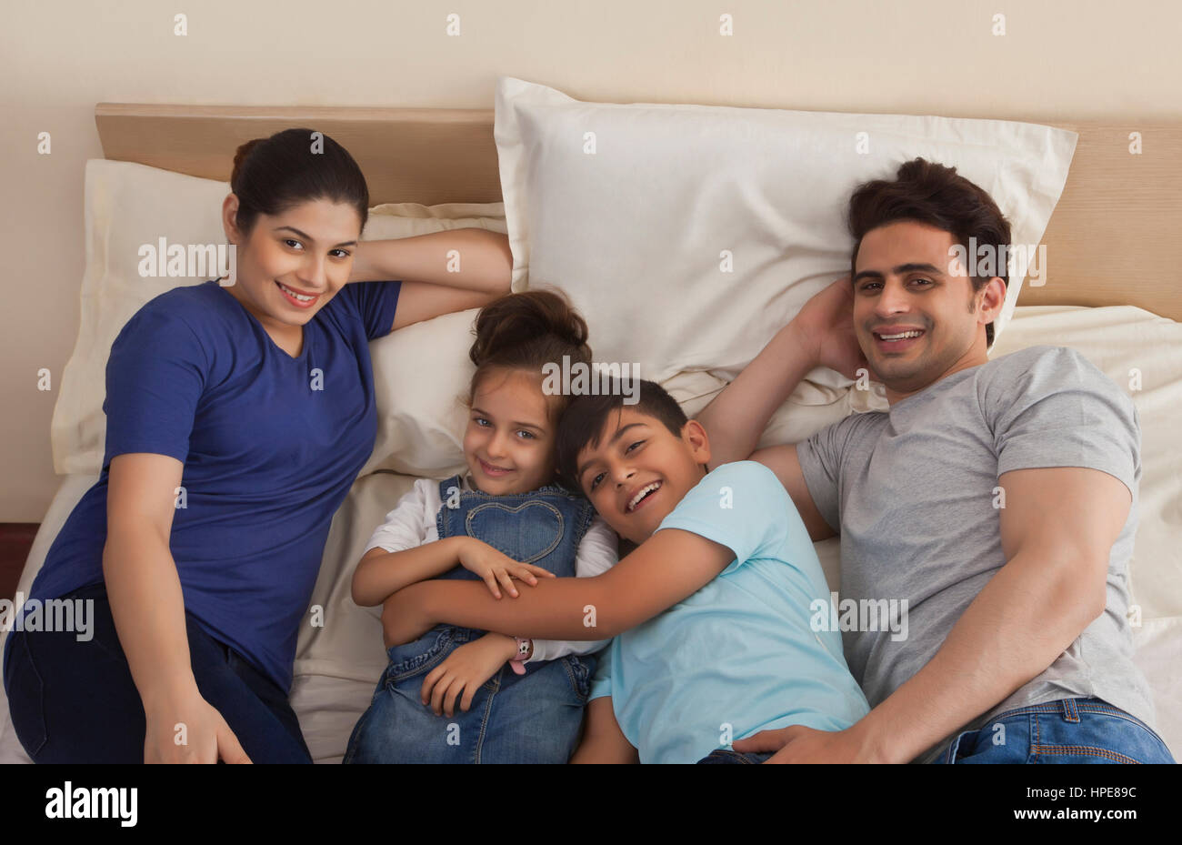 Porträt des Lächelns Familie entspannend auf Bett Stockfoto