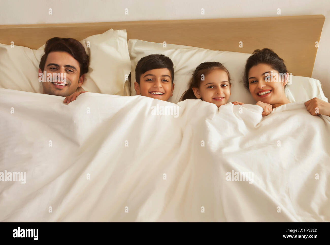 Familie im Bett liegend Stockfoto