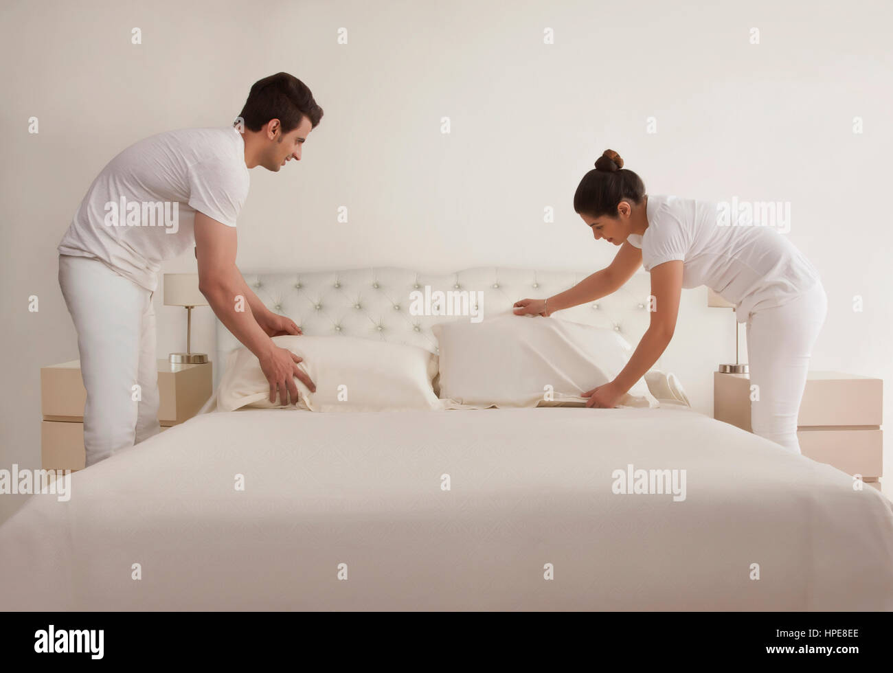 Junges Paar Bett machen Stockfoto