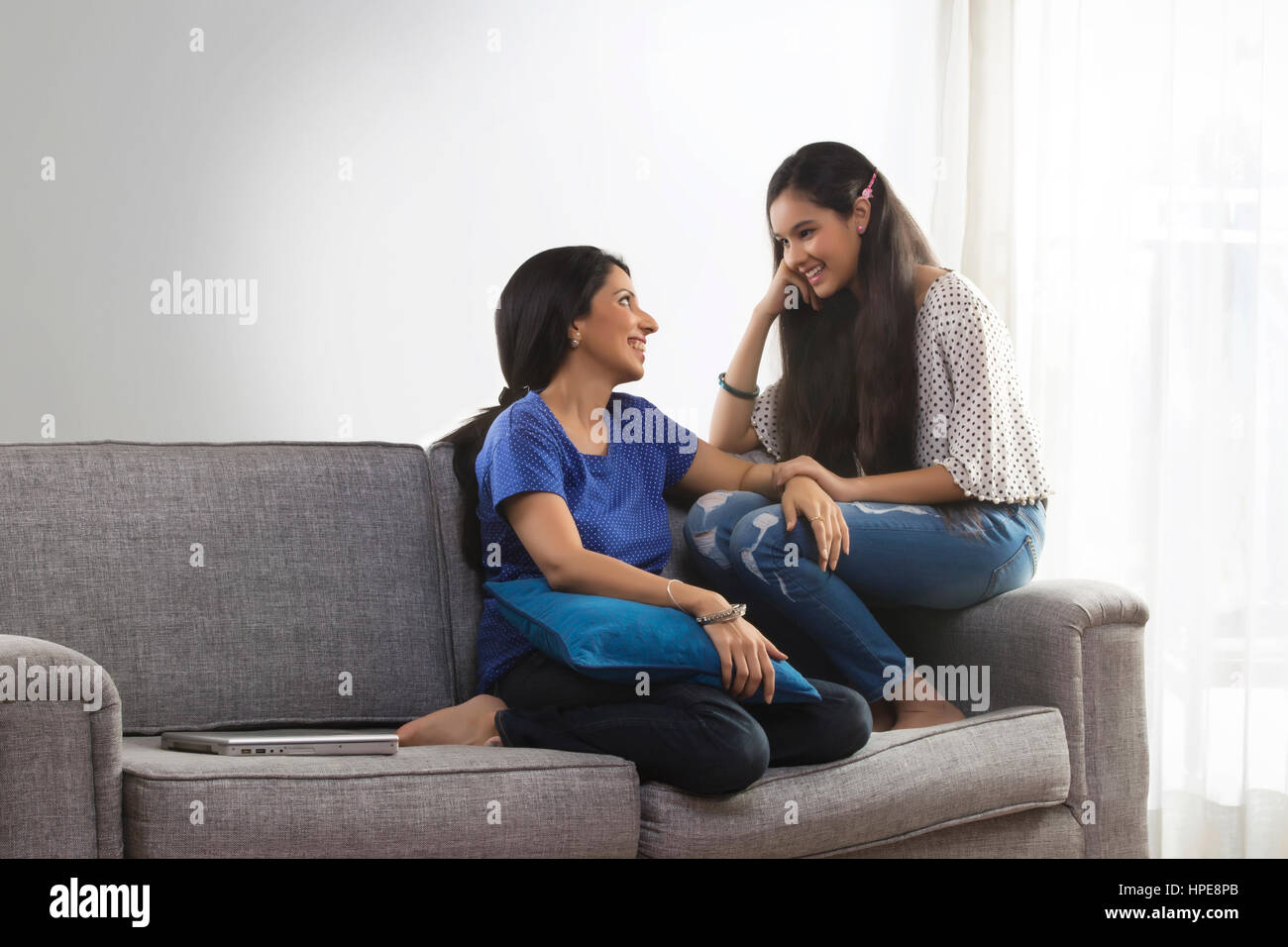 Mutter im Gespräch mit ihrer Tochter sitzt auf dem Sofa im Wohnzimmer Stockfoto
