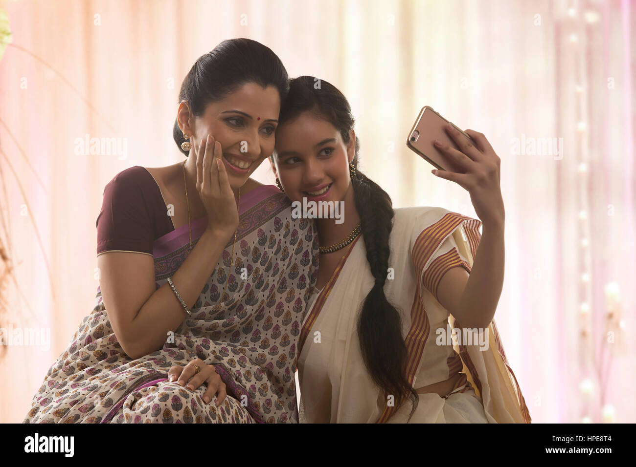 Lächelnde Teenager-Tochter in Sari und Mutter selfie Stockfoto