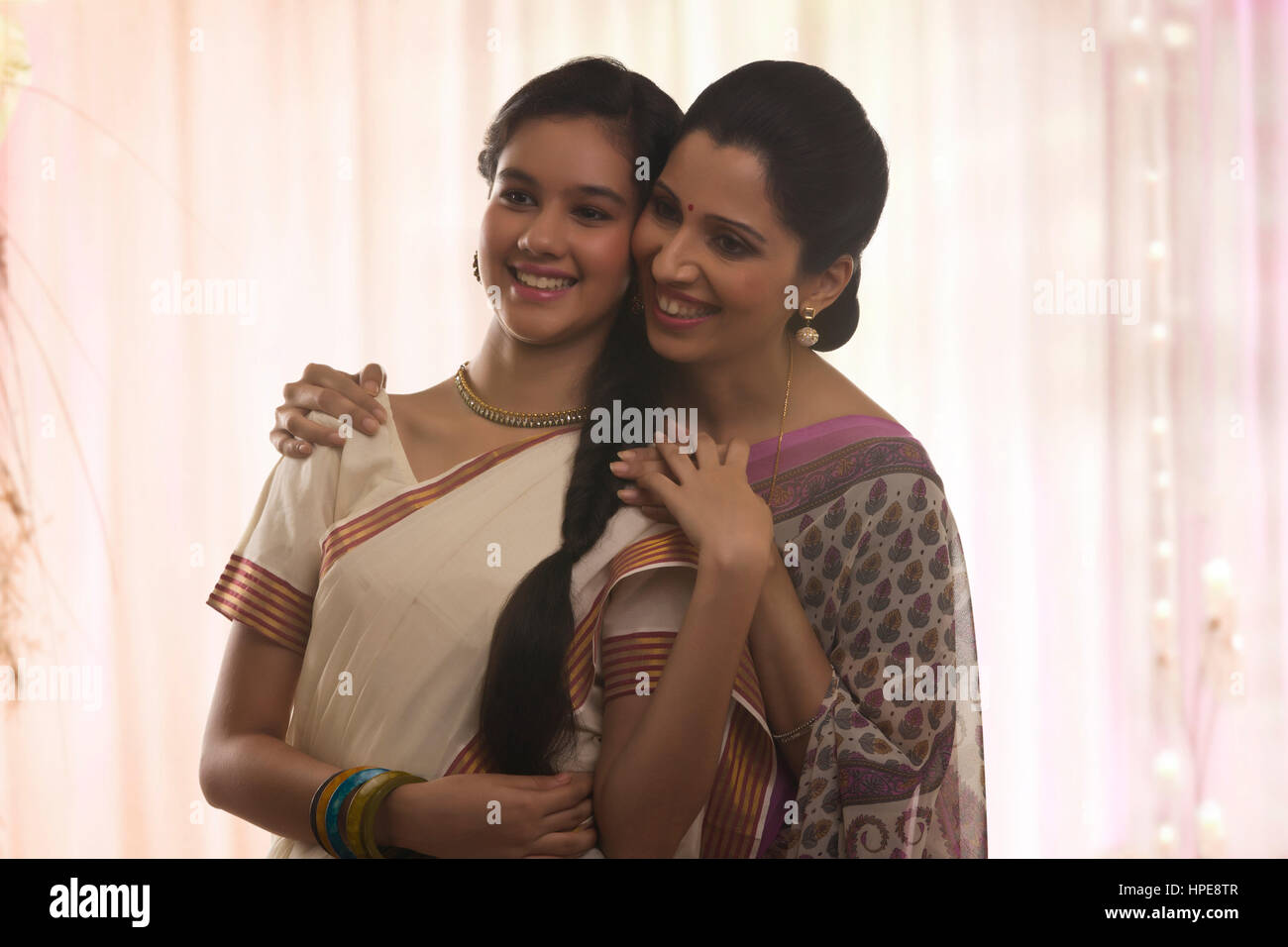 Lächelnde Teenager-Tochter in Sari mit der Mutter Stockfoto