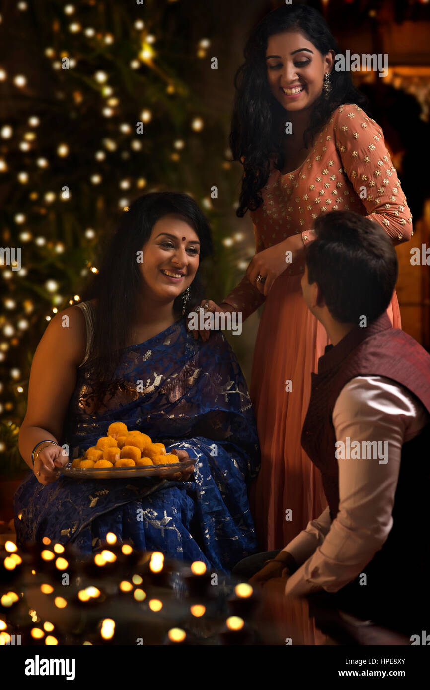 Frau mit ihrer Tochter und Schwiegersohn feiern Diwali Stockfoto