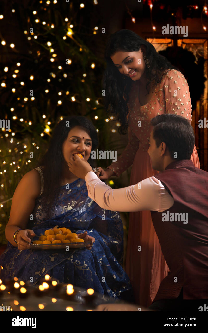 Mann, die Verfütterung von Laddoo an seine Mutter auf Diwali-fest Stockfoto