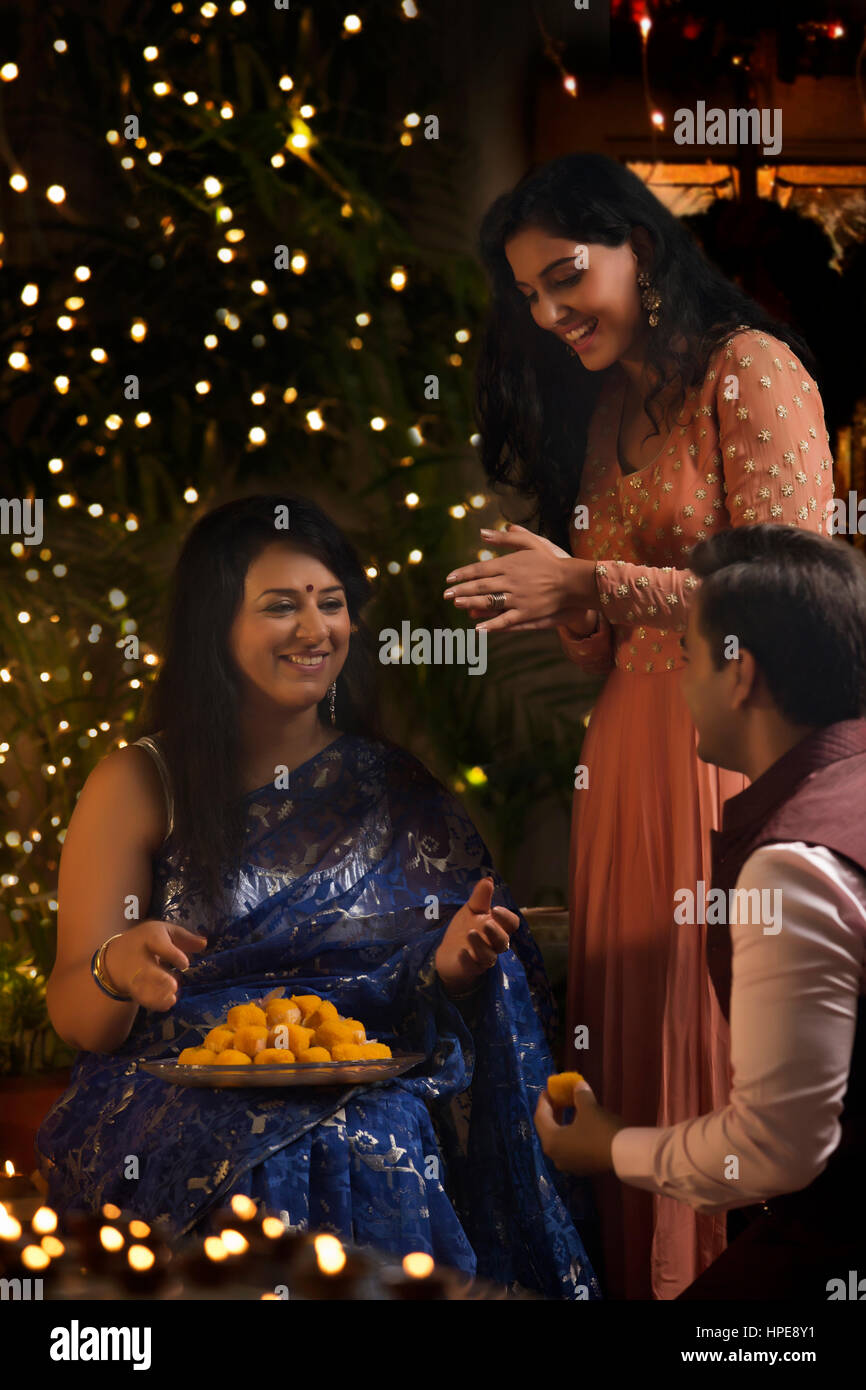 Frau mit ihrer Tochter und Schwiegersohn feiern Diwali Stockfoto