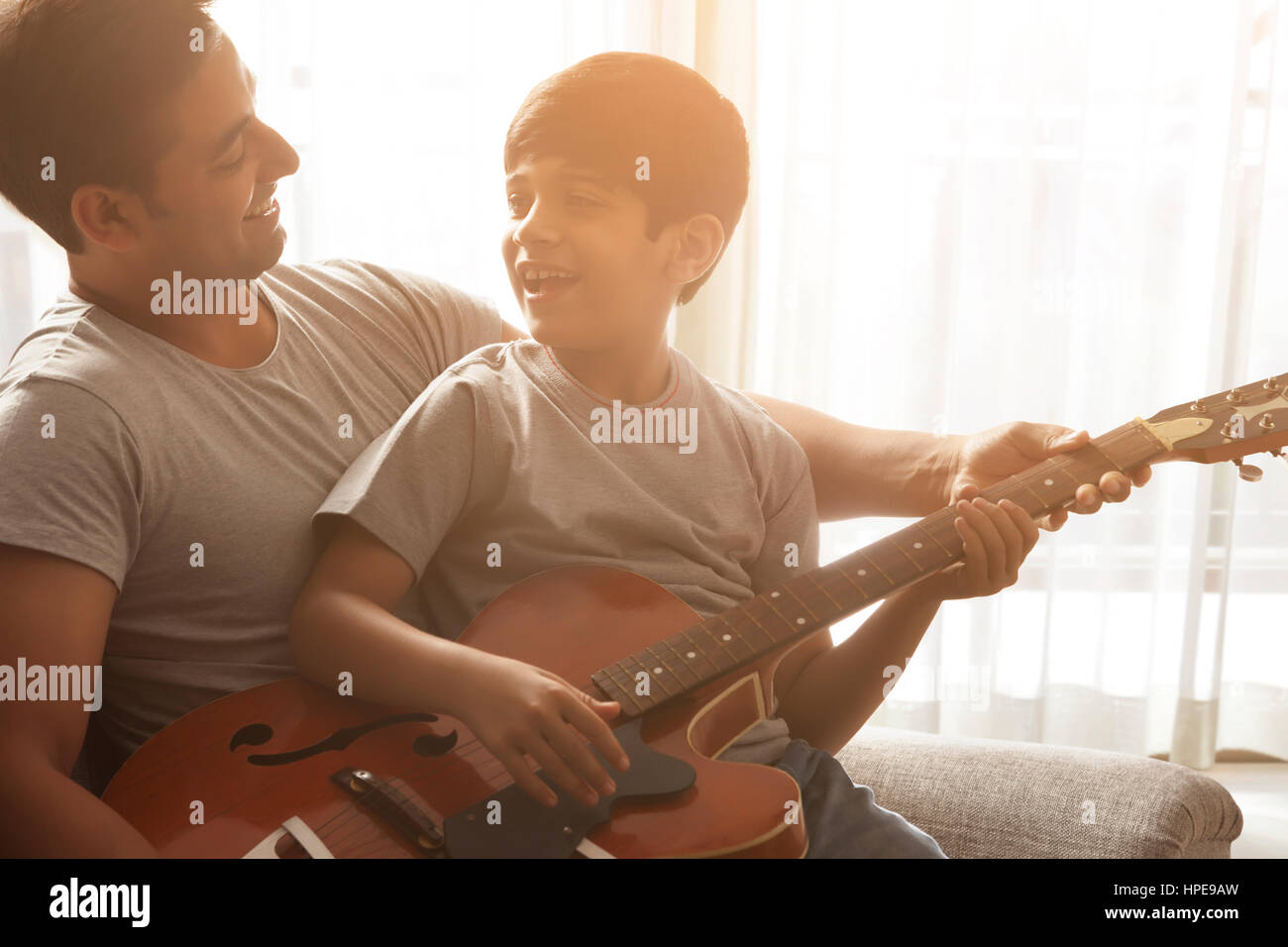 Junge mit seinem Vater Gitarrespielen lernen Stockfoto