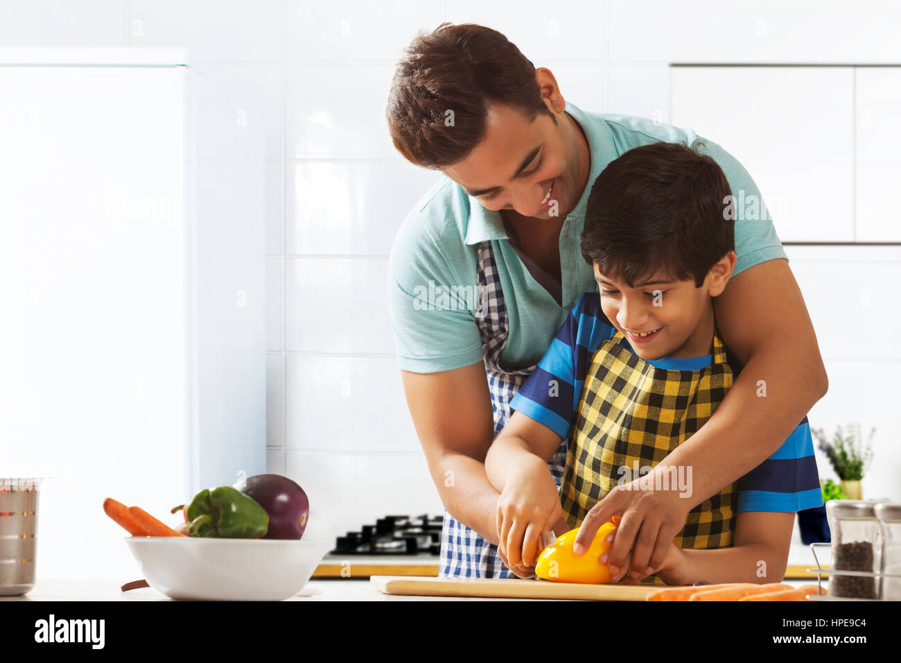 Vater Lehre Sohn, schneiden Sie Gemüse in Küche Stockfoto