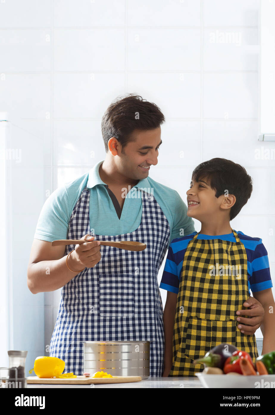 Vater und Sohn Verkostung Suppe beim Kochen in der Küche Stockfoto