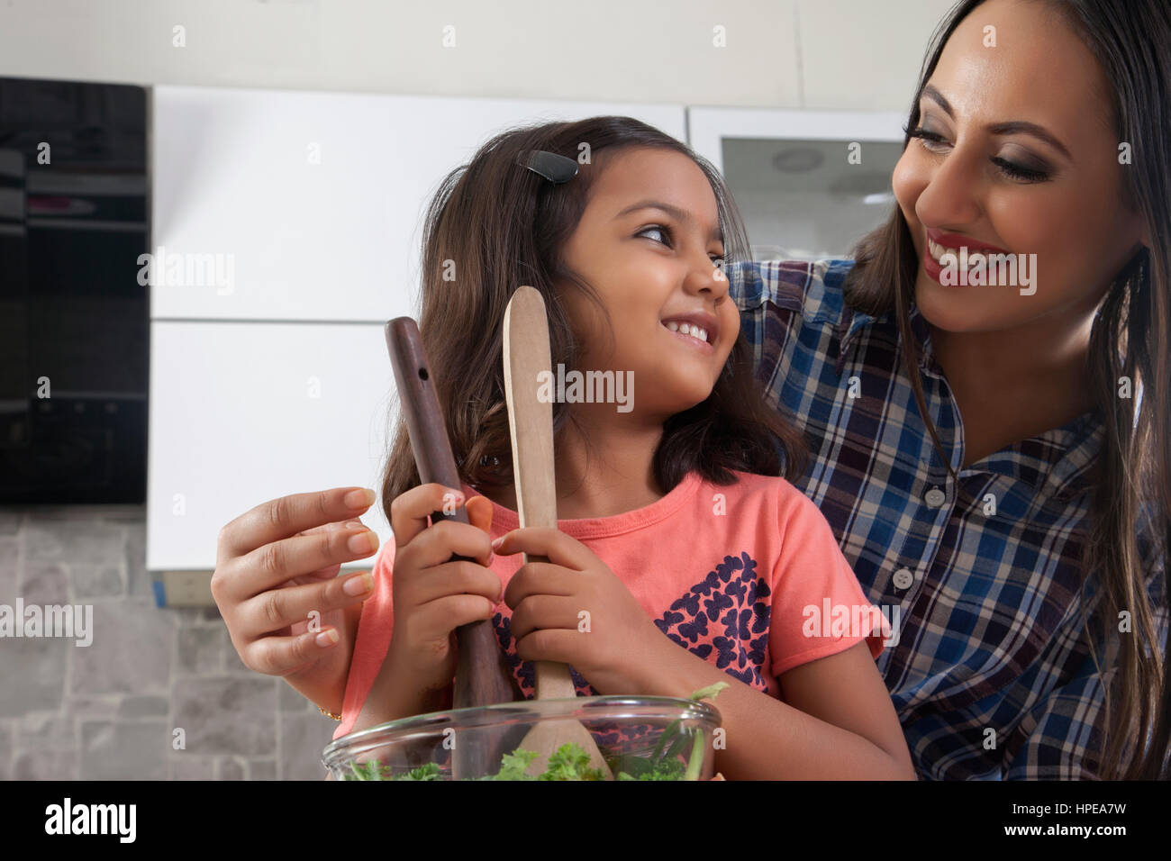 Mutter und Tochter bereitet frischen Salat in Küche Stockfoto
