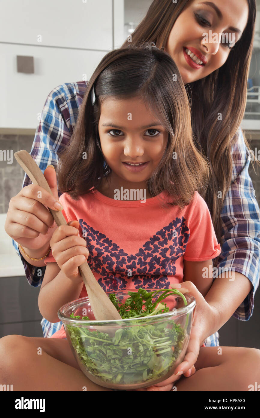 Mutter und Tochter bereitet frischen Salat in Küche Stockfoto