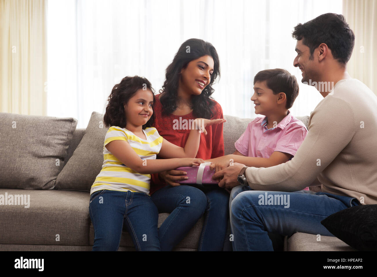 Glückliche Familie von vier hält eine Geschenk-box Stockfoto