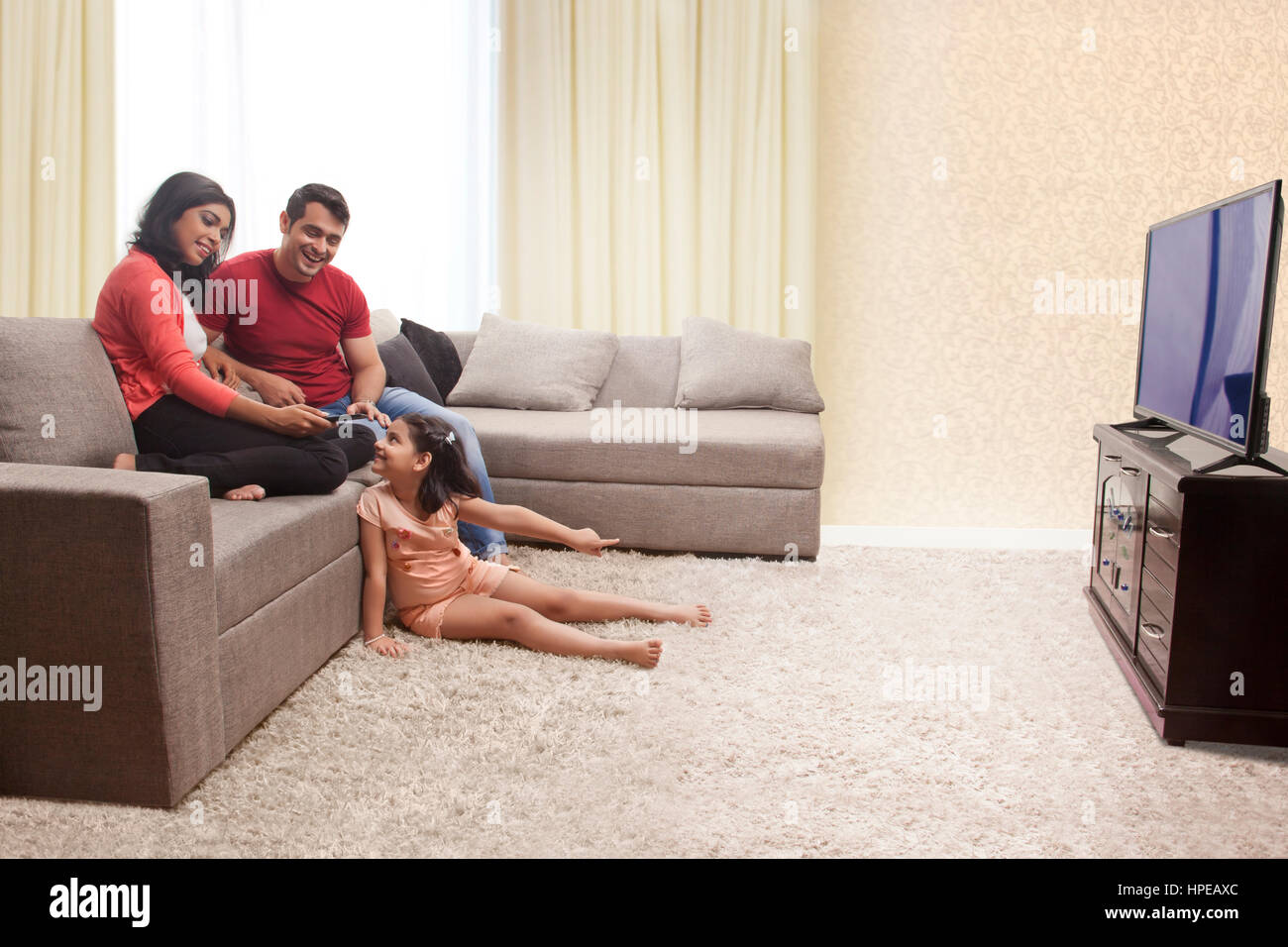 Mutter, Vater und Tochter auf Sofa sitzen und Fernsehen Stockfoto