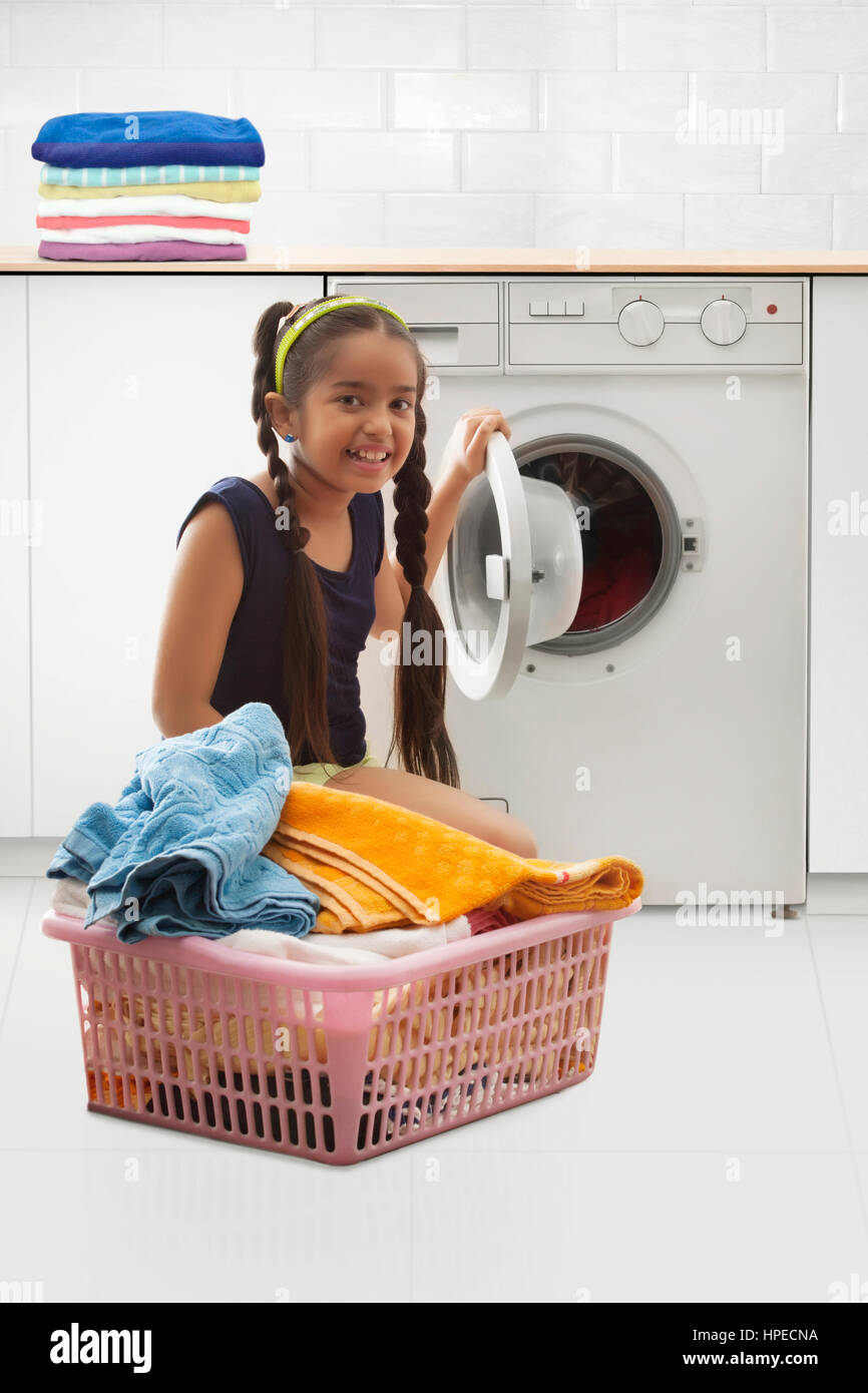Junges Mädchen beim Laden der Waschmaschine Stockfoto