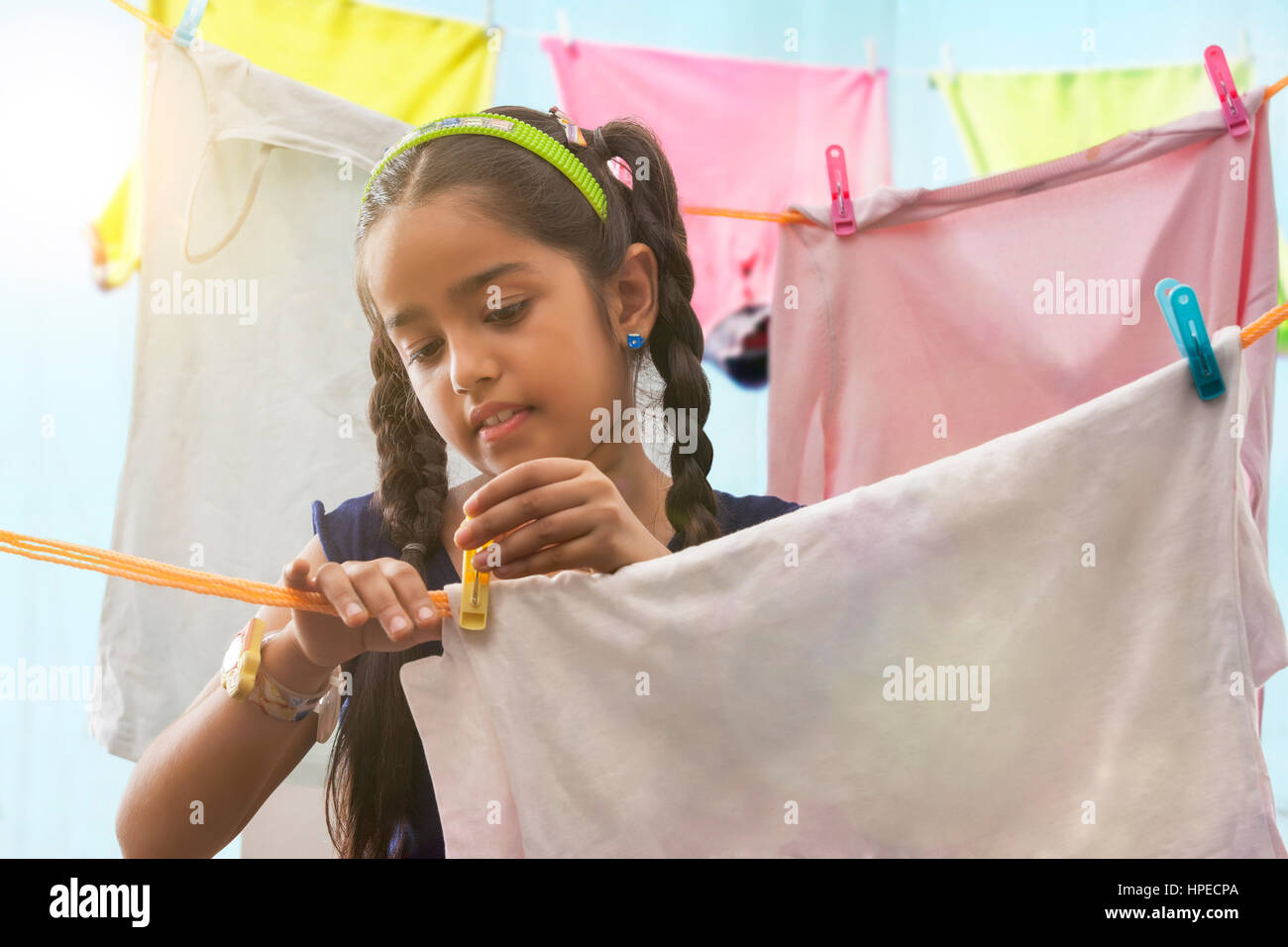 Junges Mädchen Tücher auf einer Wäscheleine trocknen Stockfoto