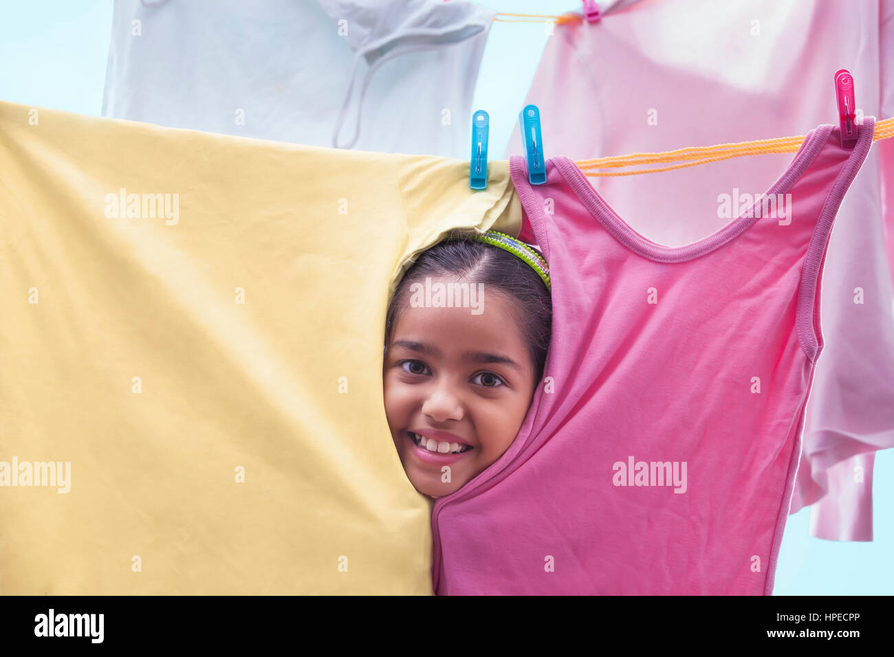 Junges Mädchen spähen durch Tücher auf einer Wäscheleine Stockfoto