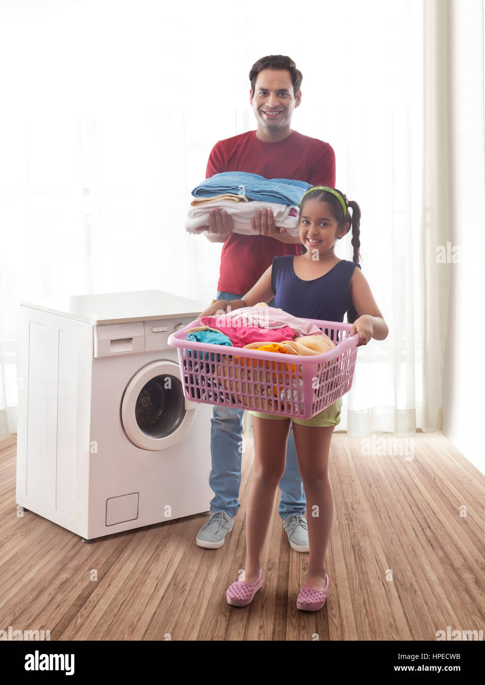 Vater und Tochter, die Wäsche im Hauswirtschaftsraum Stockfoto