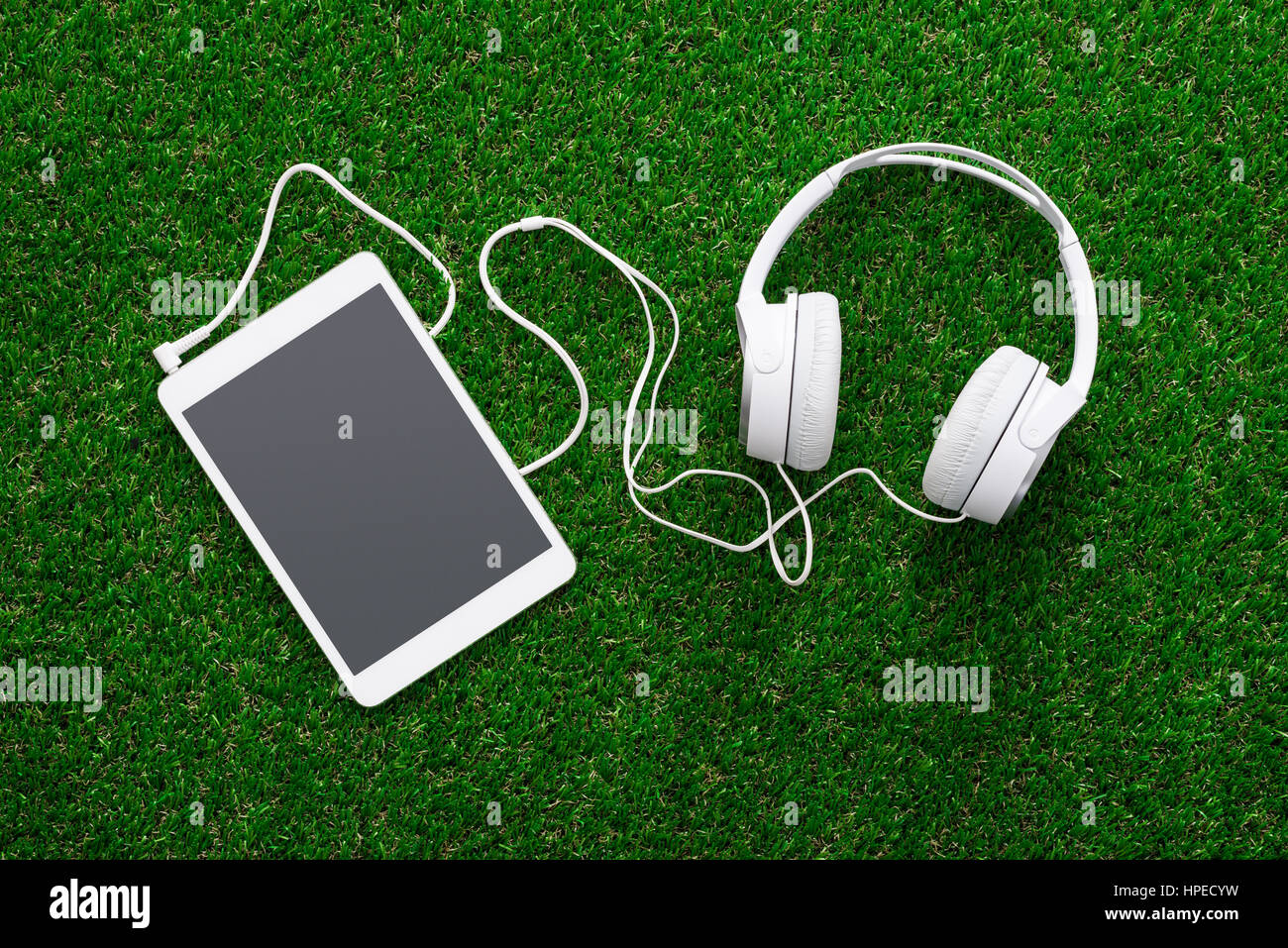 Kopfhörer und digitale Touchscreen tablet auf dem Garten Rasen: Entspannung und Freizeit-Konzept Stockfoto