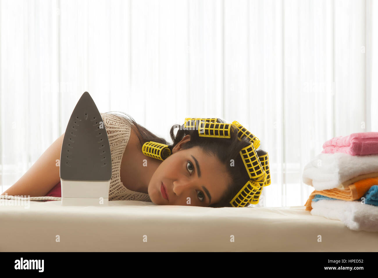 Junge Frau mit Lockenwickler schlafen am Bügelbrett Stockfotografie - Alamy