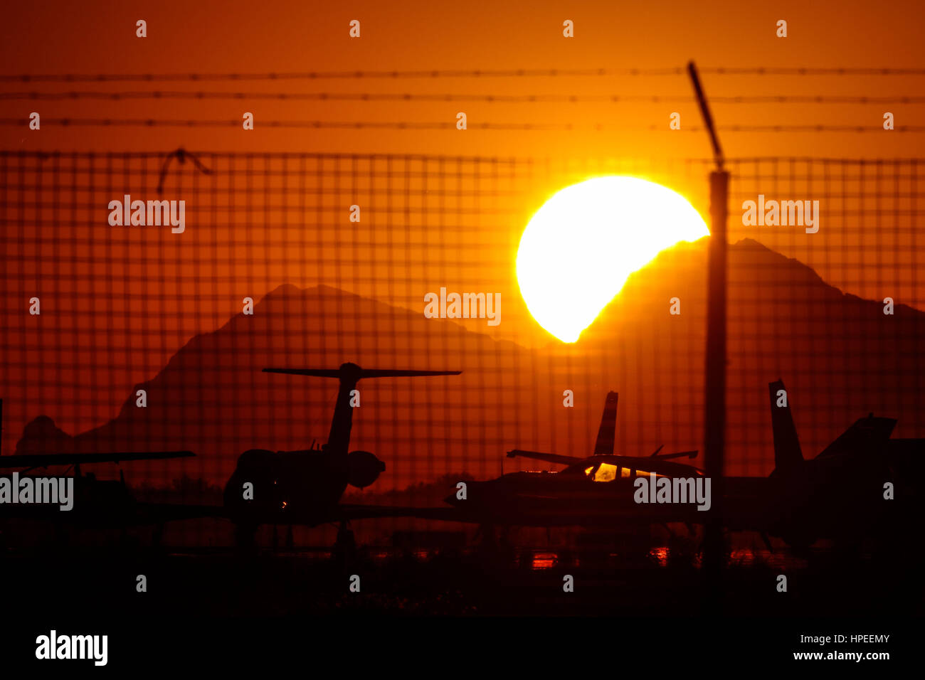 Strahlende Sonne und intensiv Orange und Gold Farbe. Sehen Sie einen beeindruckende solar Kreis bei Sonnenuntergang mit den Flugzeugen am Flughafen Stockfoto