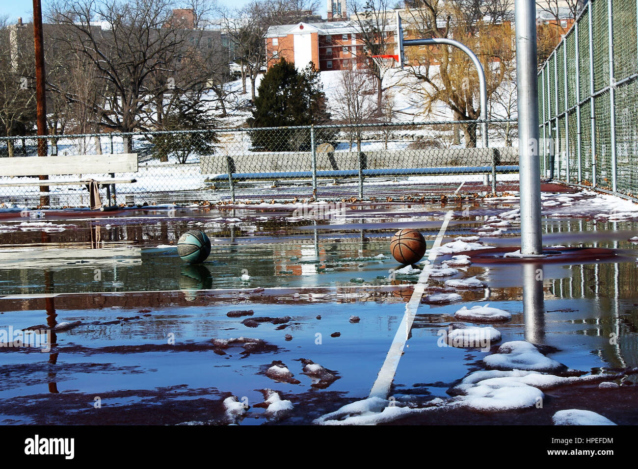 Machten einen Spaziergang durch ein Stadtteilpark zu finden zwei verlassene Basketbälle Verlegung auf Schnee und Eis bedeckten Hof. Nichts als Ruhe! Stockfoto