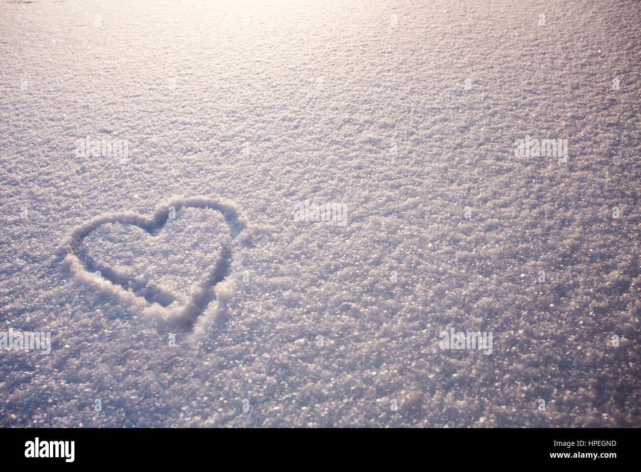ein Herz auf weißen Schnee am Valentinstag Stockfoto