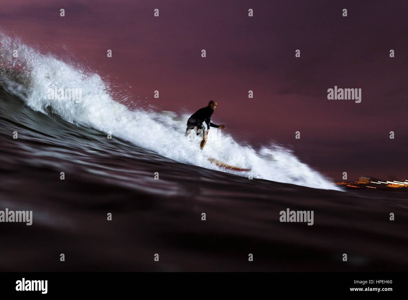Surfer auf einer Welle in der Nacht Stockfoto