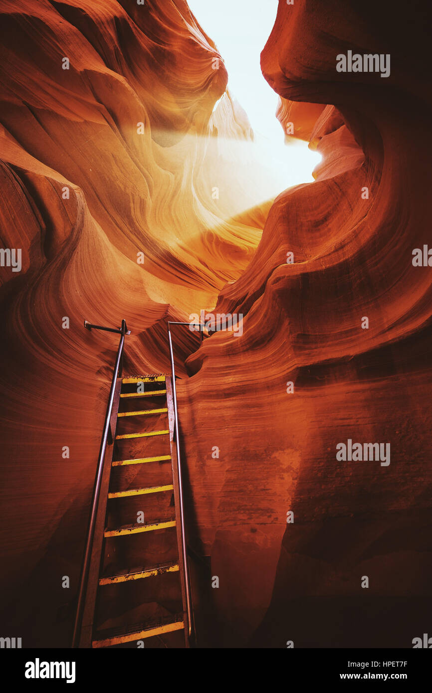 Schöne Aussicht auf erstaunliche Sandstein-Formationen mit einer Leiter, die gegen eine magische Lichtstrahl in berühmten Antelope Canyon in der Nähe von Page, Arizona, USA Stockfoto