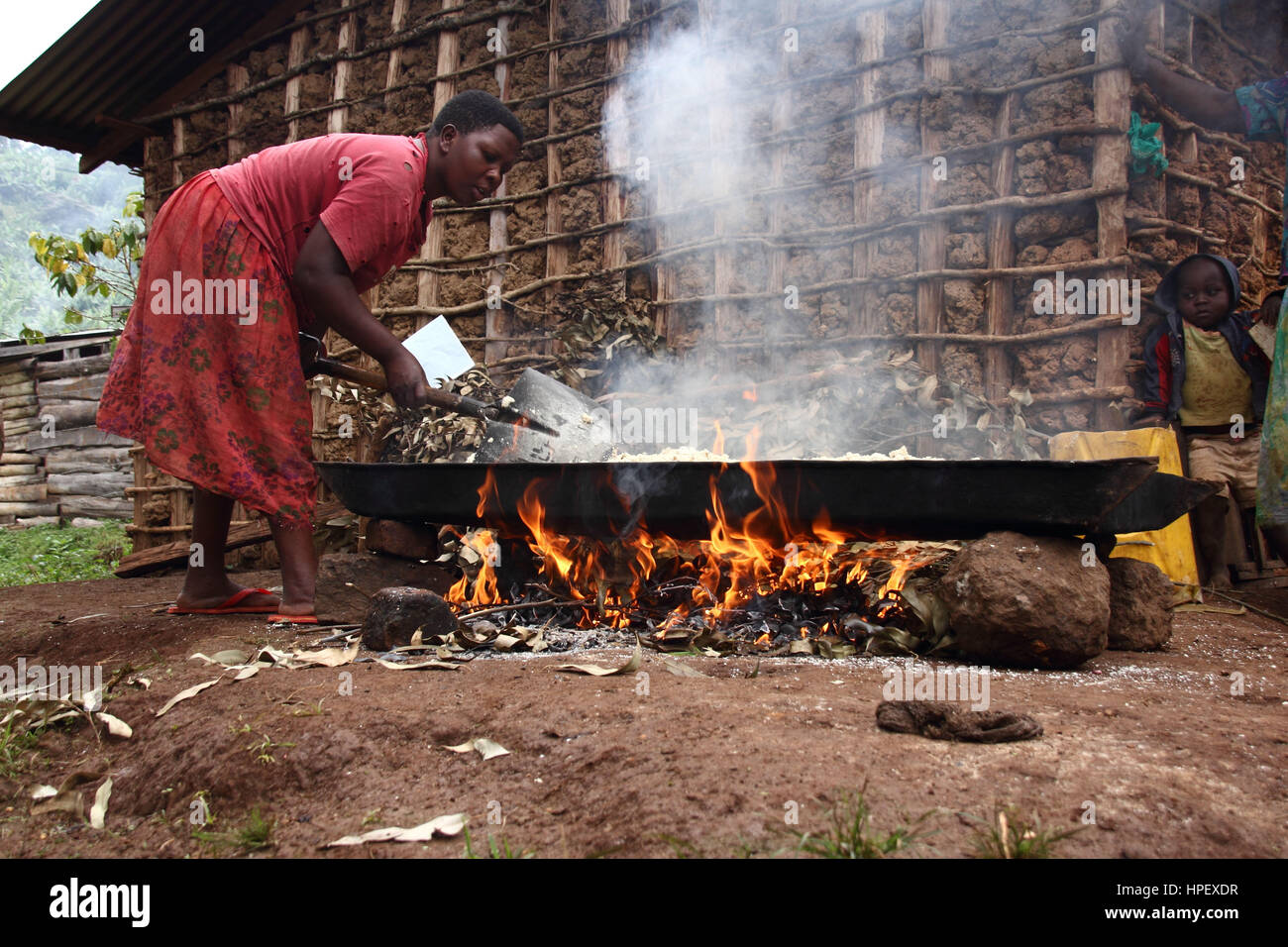 Einheimische Frau mit Baby Rösten Hopfen Stockfoto