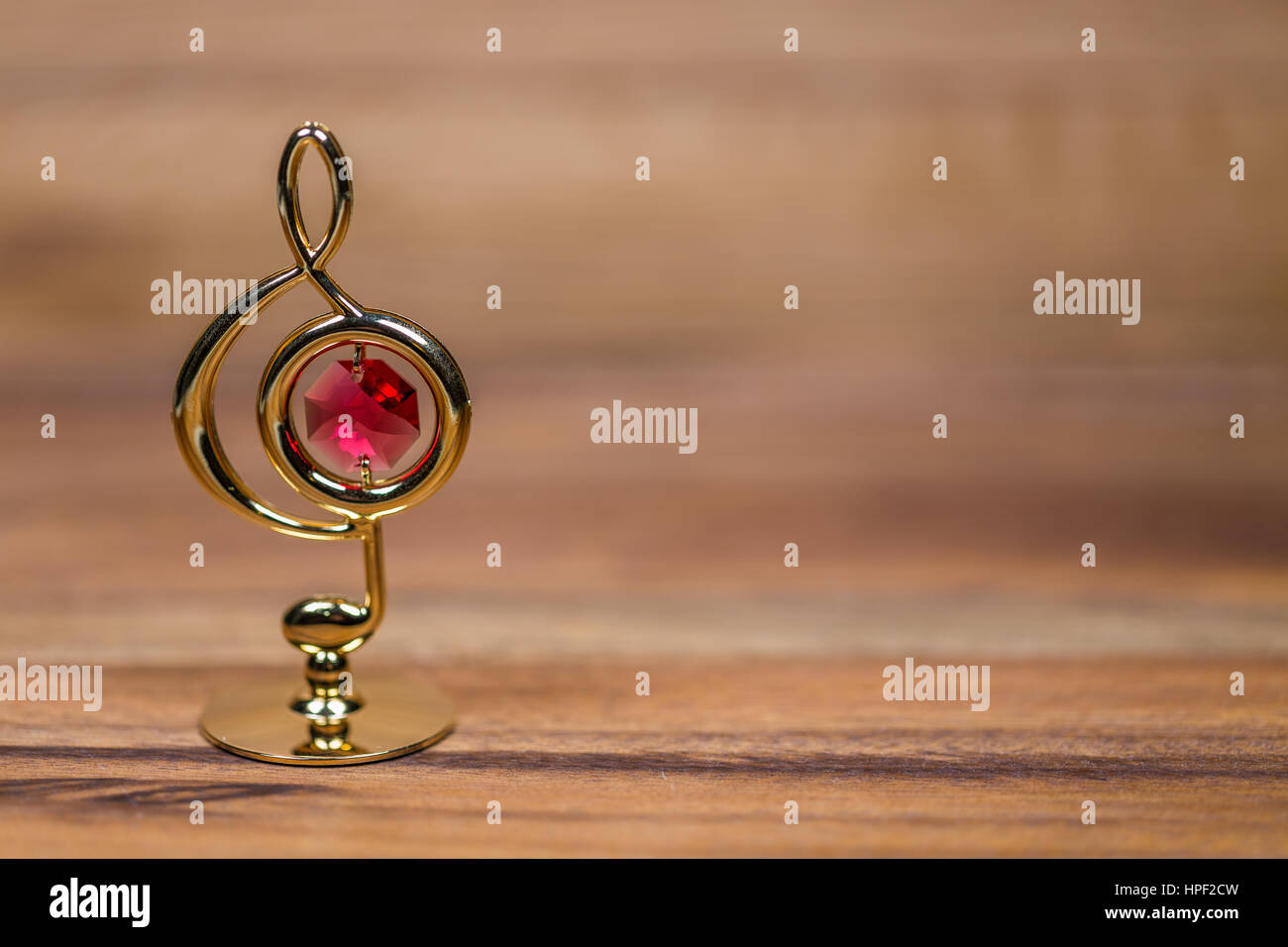 Goldener Violinschlüssel Figur mit roter Kristall Stockfoto