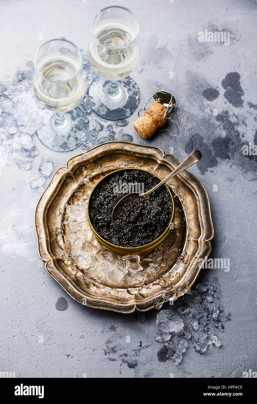 Schwarz-Stör-Kaviar in kann auf Eis und Champagner auf konkrete Hintergrund Stockfoto