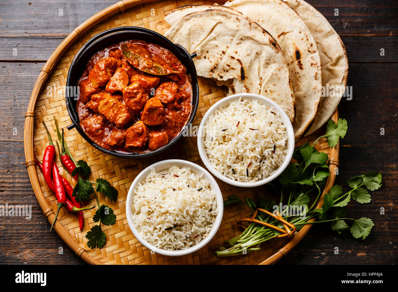 Chicken Tikka Masala scharfes Curry Fleisch Essen im Eisentopf mit Reis und Naan Brot hautnah Stockfoto