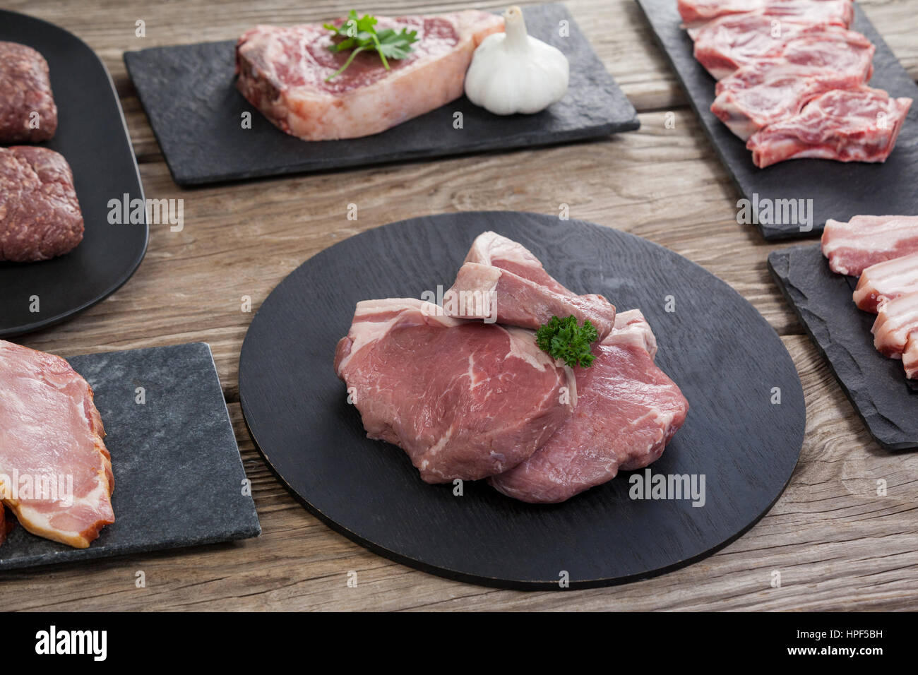 Sorten von Fleisch auf schwarzen Tablett aus Holz Hintergrund Stockfoto