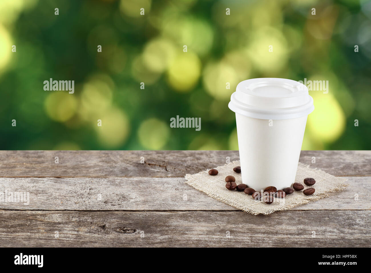 Pappbecher Kaffee auf natürliche außen Hintergrund mit Textfreiraum. Kaffee am Tisch auf Natur Hintergrund. Kaffee zum mitnehmen. Kaffee zum mitnehmen Stockfoto