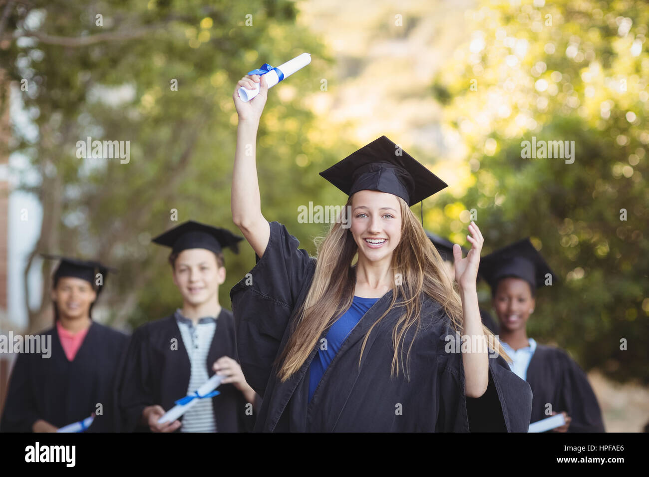 Graduiertenschule Kinder stehen mit Grad Schriftrolle auf dem Campus in der Schule Stockfoto