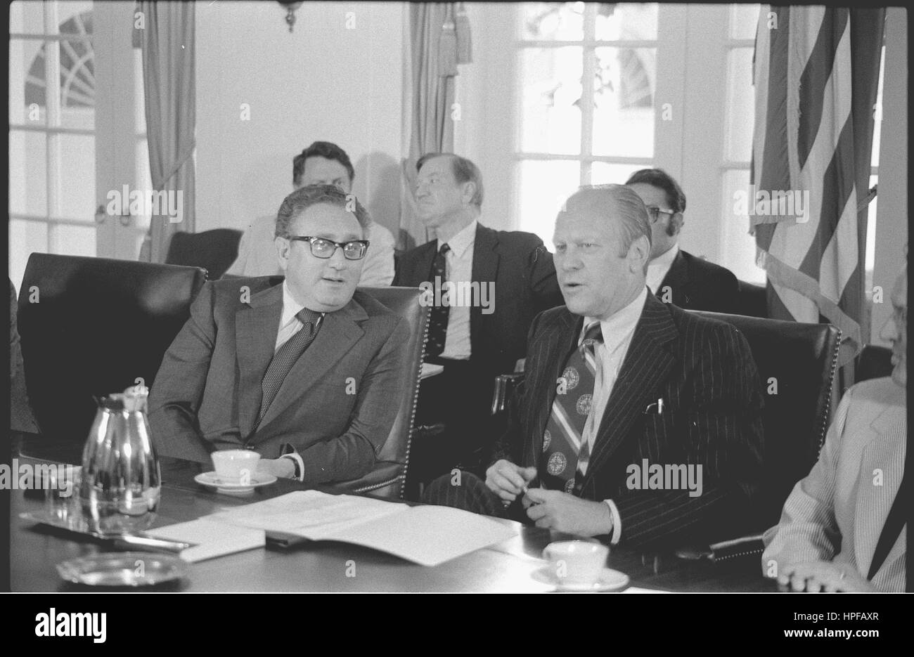 Staatssekretär Henry Kissinger und Präsident Gerald Ford sitzen an einem Konferenztisch im Weißen Haus während einer Kabinettssitzung, Washington, DC, 04.06.1975. Stockfoto