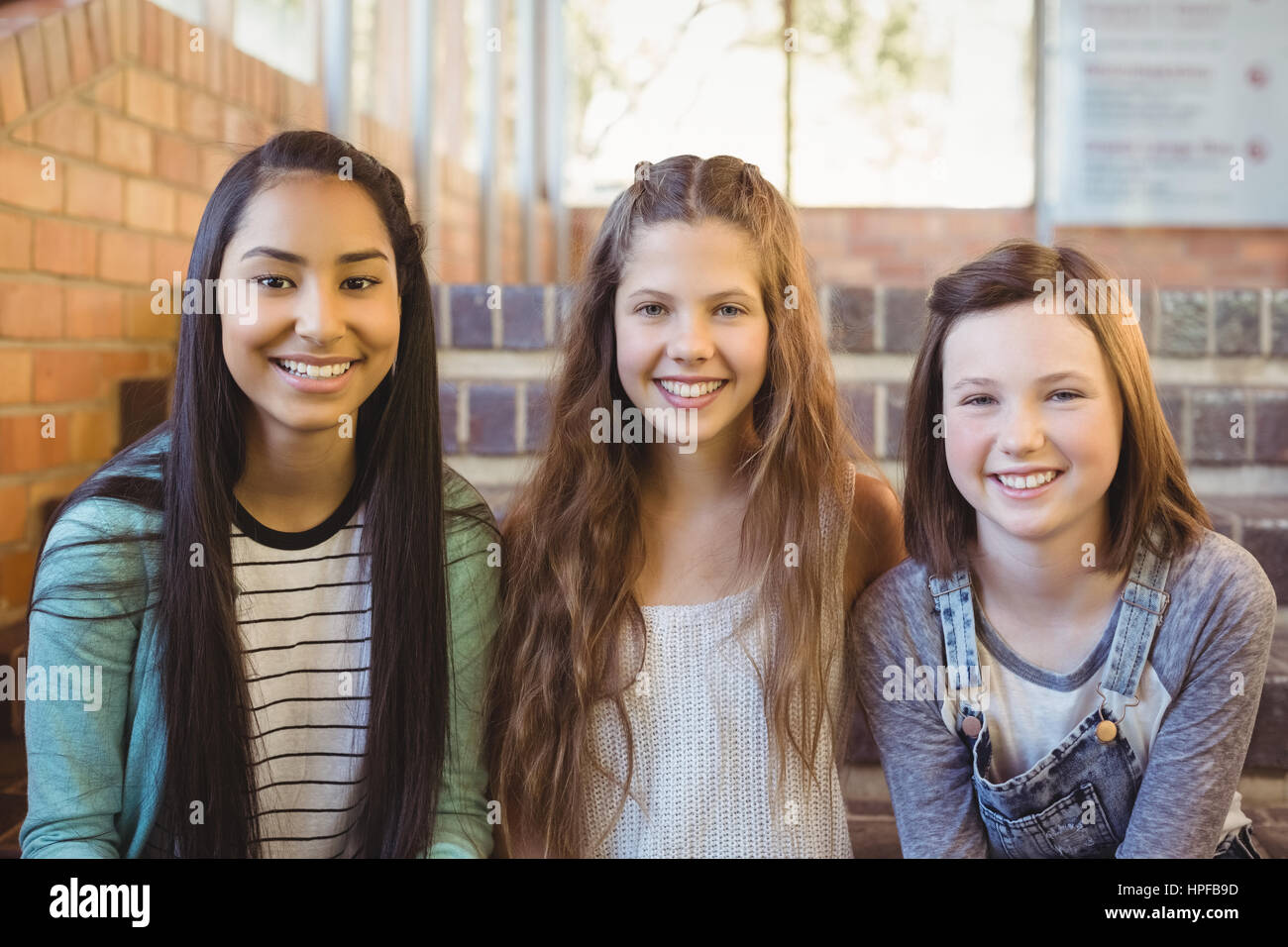 Porträt des Lächelns Schülerinnen sitzen auf der Treppe in der Schule Stockfoto