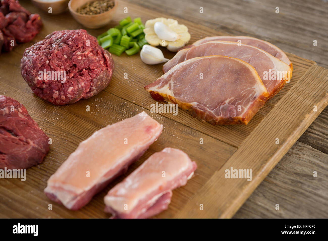 Sorten von Fleisch und Gewürzen auf Holztablett aus Holz Hintergrund Stockfoto