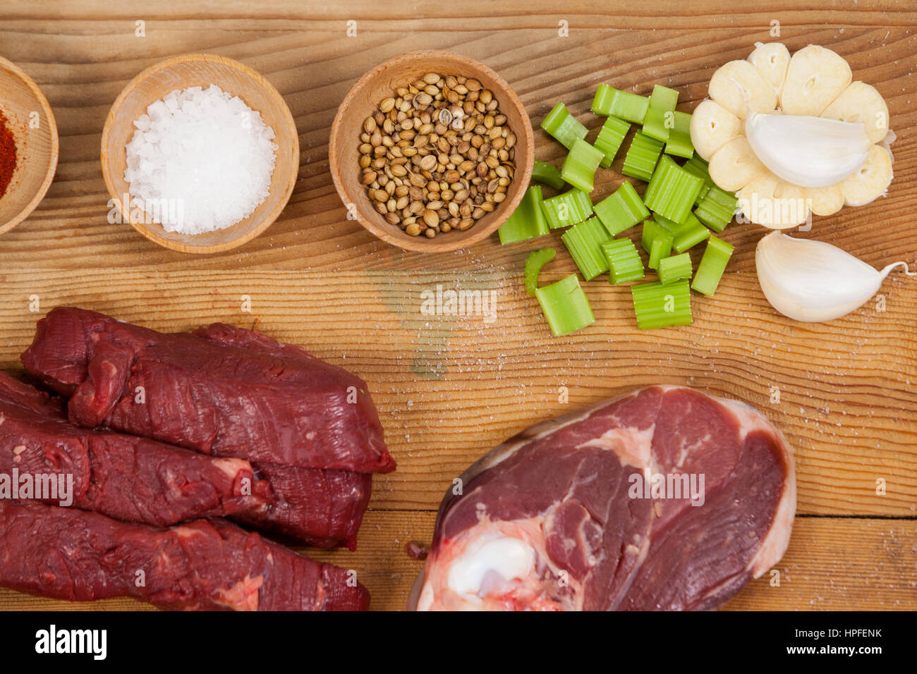 Sorten von Fleisch mit Gewürzen auf Holzbrett vor weißem Hintergrund Stockfoto