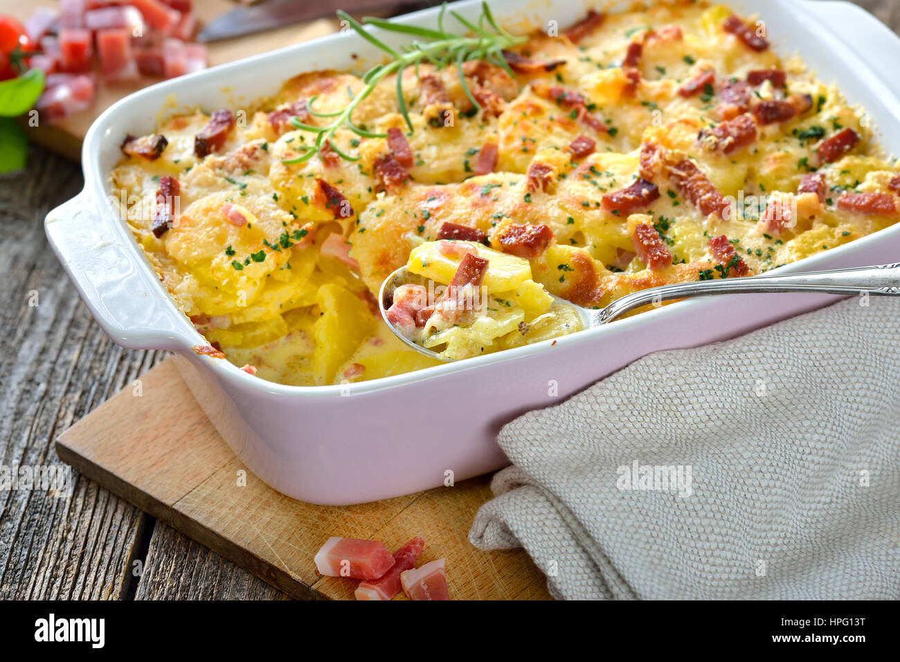 Frisch aus dem Ofen serviert herzhafte Kartoffel-Gratin mit Parmesan-Käse, Sahne und köstlichen Speck aus Südtirol Stockfoto