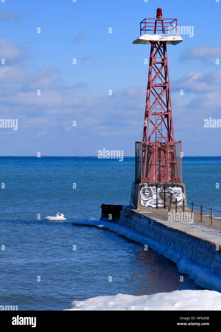 Leuchtturm am Pier ragt heraus in Lake Michigan an kalten Wintertag im Januar mit gefrorenen Seewasser Stockfoto