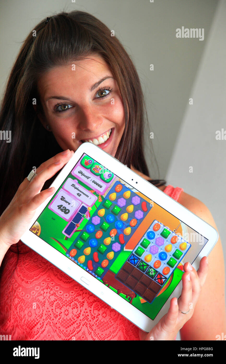 Frankreich, junge Frau spielen Candy Crush auf ihr tablet Stockfoto