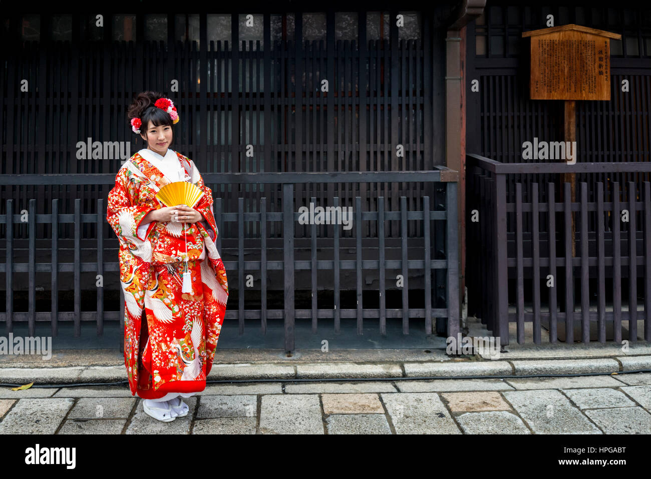 Junge japanische Braut im Kimono stehen außerhalb eines alten Gebäudes, Gion Bezirk, Kyoto, Japan Stockfoto